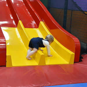  Young child on the soft play slide