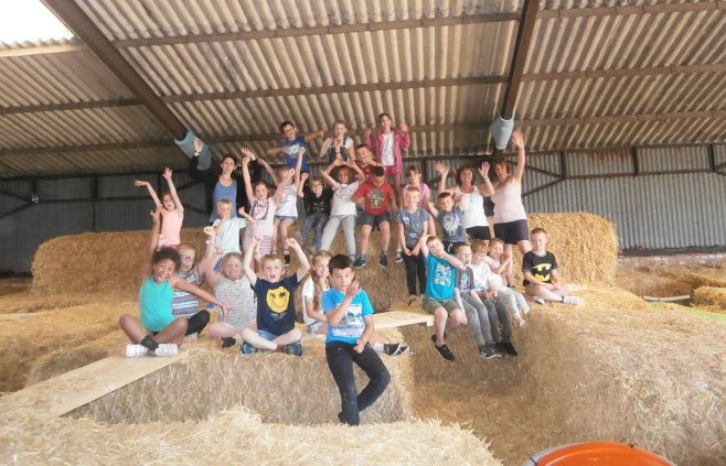 Children sitting on hay bales
